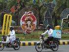 Motorcyclists drive past an ad for the postponed Pakistan Super League in Lahore. (AP PHOTO)